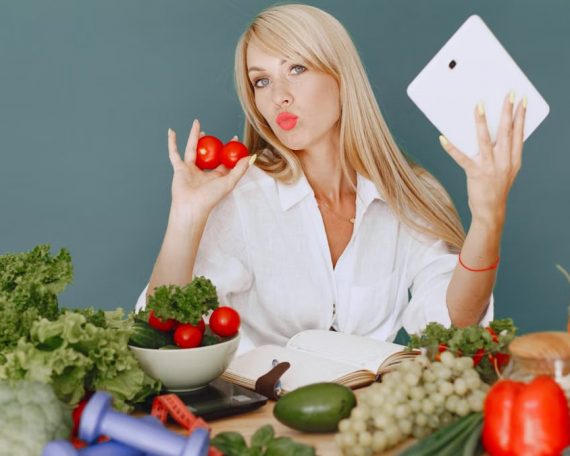 Vlogger promoting healthy eating with fresh vegetables on the table.